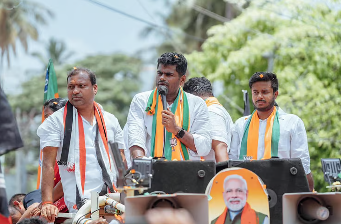 ஆதர்ஷ் மற்றும் கைலாஷ் கோவையில் ஒரு சிறிய கூட்டத்தில் பாஜக கொடிகளுடன் உரையாற்றும் காட்சி.