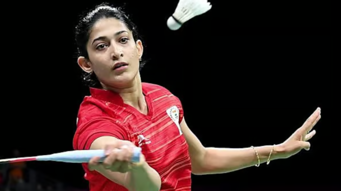 பேட்மிண்டன் வீராங்கனை அஸ்வினி பொன்னப்பா நீதிமன்றத்தில் விளையாடுகிறார், அவர் முகத்தில் மனஉறுதி தெரிகிறது.