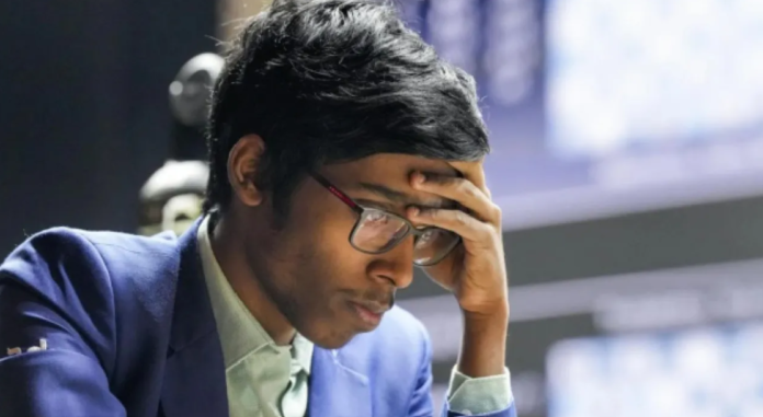 கேண்டிடேட்ஸ் செஸ் தொடரில் ஆழ்ந்த சிந்தனையுடன் சதுரங்கப் பலகையை உற்றுநோக்கும் பிரக்ஞானந்தா.