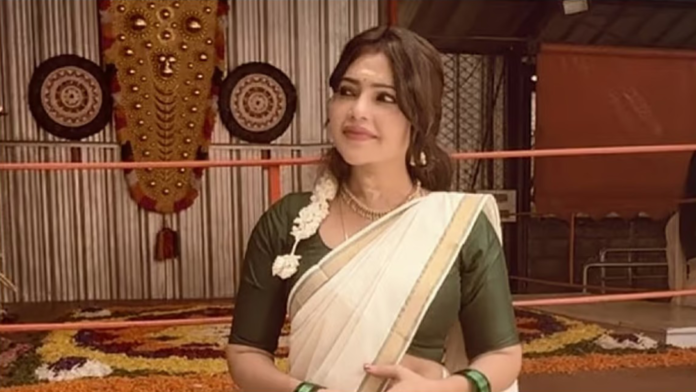 சின்னத்திரை நடிகை சுபாஷினி புன்னகைக்கும் புகைப்படம், பின்னணியில் ஒரு சோகமான நிழல் உருவம்.