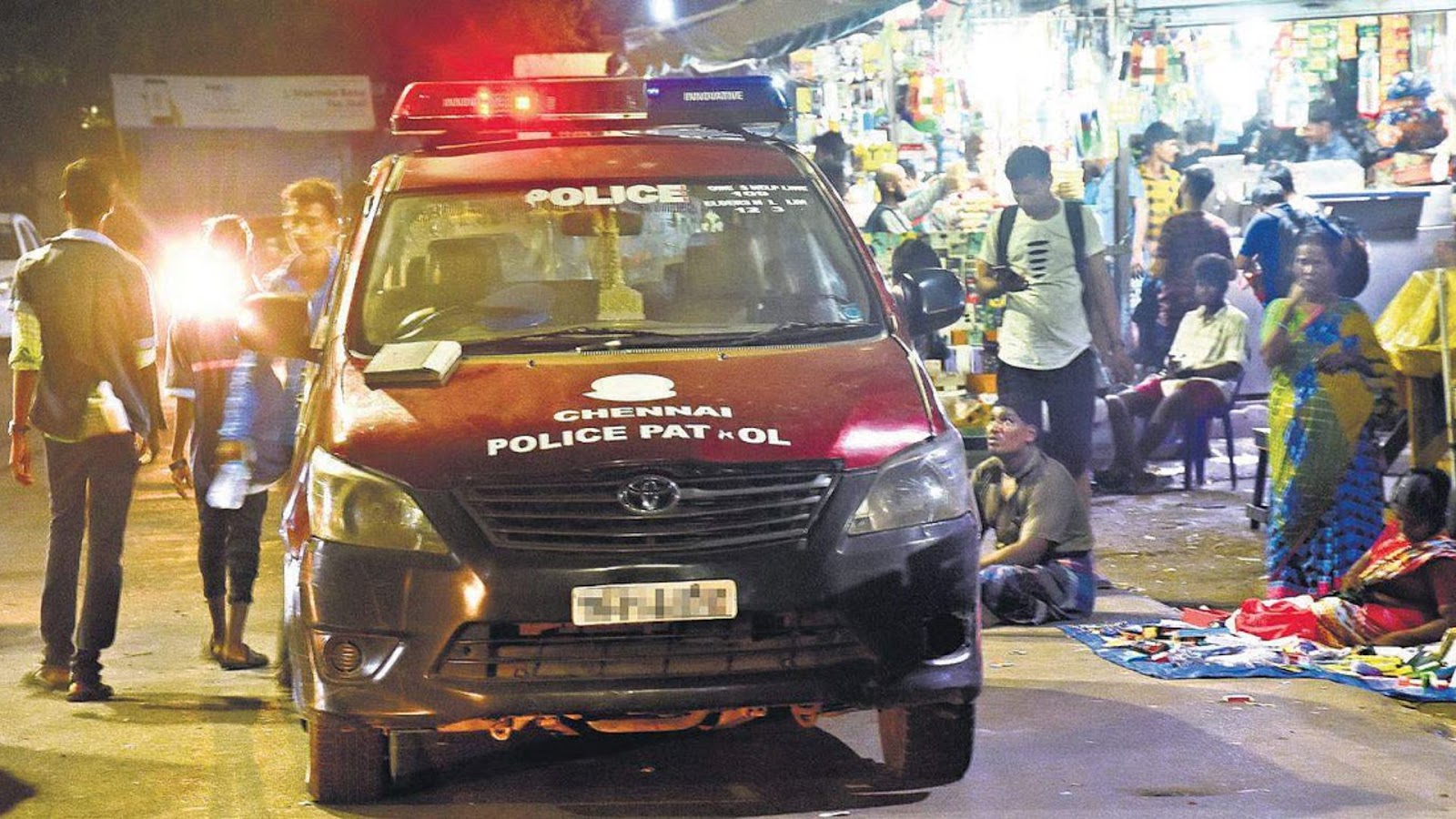 இரவு நேரத்தில் காவலர்களால் சோதனையிடப்படும் மொபைல் போன் கடை