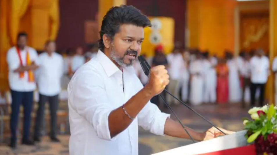 நடிகர் விஜய் தனது அரசியல் கட்சியின் பொதுக்கூட்டத்தில் பெருந்திரளான மக்களிடம் உரையாற்றும் காட்சி.
